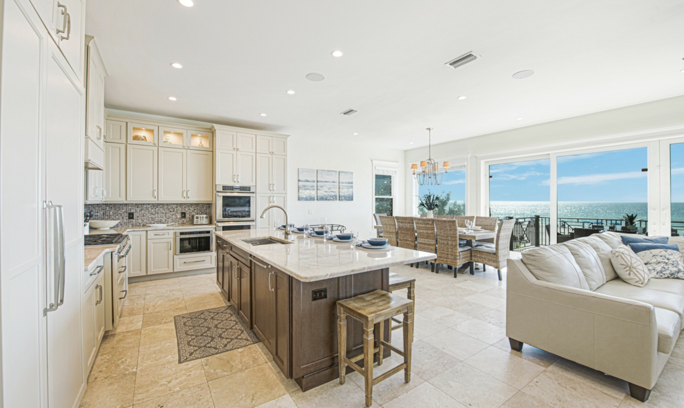 a kitchen and living room with a large island and a view of the ocean